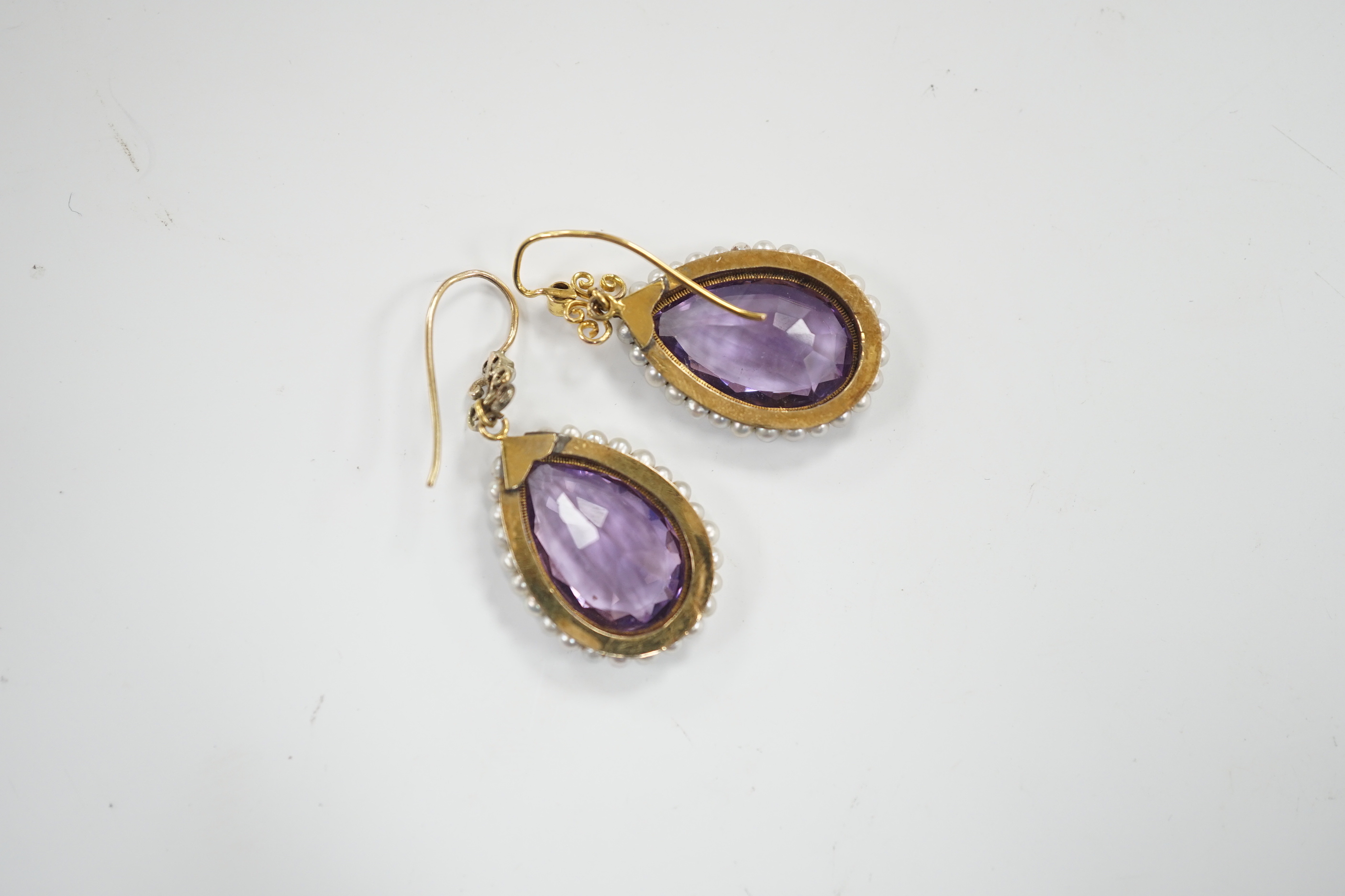 A pair of Victorian yellow metal, amethyst and seed pearl set teardrop shaped drop earrings, 21mm, gross weight 5.5 grams.